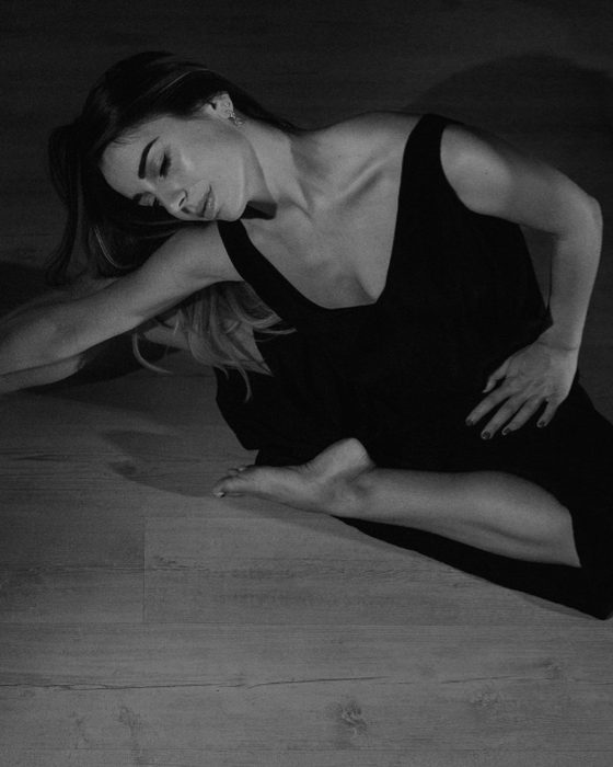 Carlotta Costantini a terra in una posa di danza contemporanea, in bianco e nero.